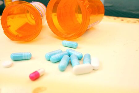 Empty pill bottles and pills on tableの写真素材