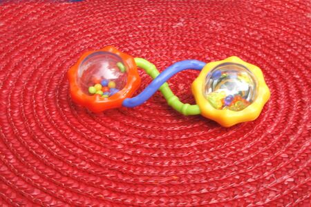 Baby rattle on red matの写真素材