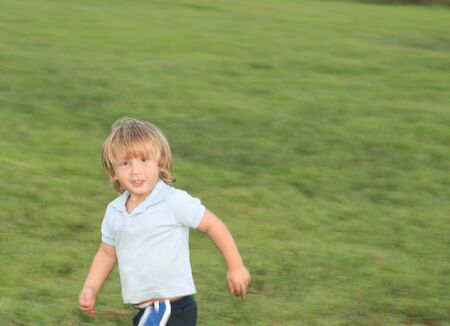 Baby boy running in the grassの写真素材