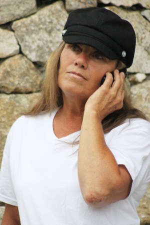 Woman in black hat talking on cell phoneの写真素材