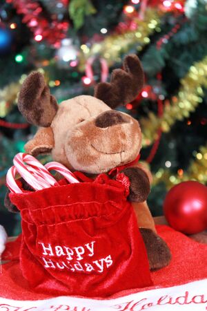 Reindeer decoration with bag of candy canes under Chrstmas treeの写真素材