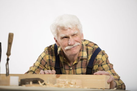 Old woodcarver work in the workshop