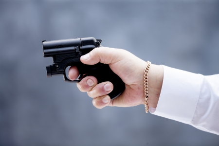 Mature adult man wearing a suit holding a gas pistol with his right hand, aiming at the target. Isolated on white background.の写真素材