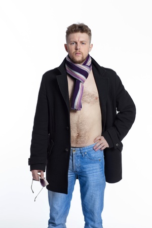 Portrait of handsome stylish blond man in sunglasses and a coat over her naked body in a beautiful stylish scarfの写真素材