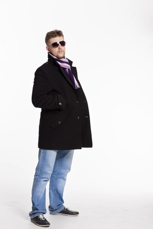 Portrait of handsome stylish blond man in sunglasses and a coat over her naked body in a beautiful stylish scarfの写真素材