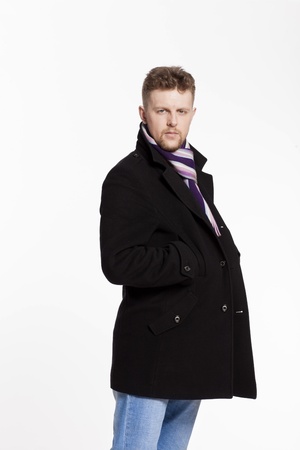 Portrait of handsome stylish blond man in sunglasses and a coat over her naked body in a beautiful stylish scarfの写真素材