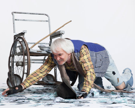 homeless man with a wheelchair with a lot of money on a white backgroundの写真素材