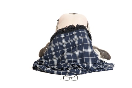 man covered with blanket lying on his knees on the floor on white backgroundの写真素材