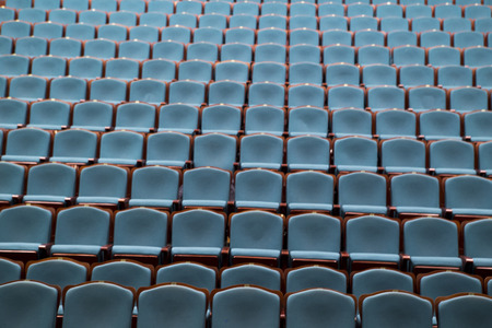 Empty rows of blue chairs in the auditorium of the theaterの写真素材