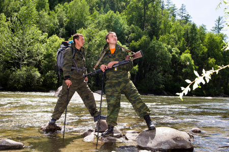 The forester and the inspector with a backpack, sleeping mat behind his back and a rifle in the trek...