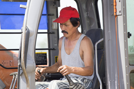 The driver-excavator driver in the cabin controls the process of moving the ground.
Driver - excavator driver in the cabin controls the process of moving the ground.
Excavator is digging a trench. Work on the construction site. Digging trenches for laying communications to the building under construction.の写真素材