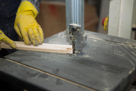 Joiner works on the machine with the wooden product manufacturing. The carpenter cuts the wood of...