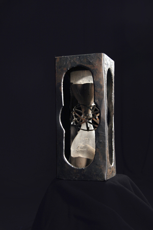 Hourglass on a black background handmade. Corus made chaser of copper.の写真素材