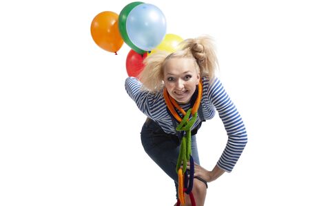 Clown girl with balloons dancing, jumping, grimacing and grimacing in studio carved on a white backgroundの写真素材
