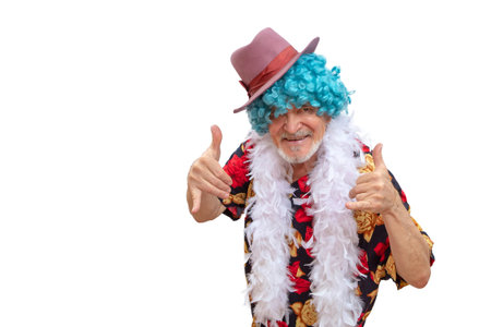 Cheerful happy man in bright clothes and a wig showing thumbs up, celebrating his luck and showing his happinessの写真素材