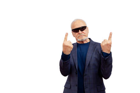 A very serious businessman in dark glasses challenges by showing his index fingers up on a white backgroundの写真素材