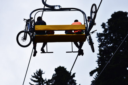 Mountain bikers on a chair lift in the mountain.