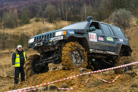 Lviv, Ukraine - February 21, 2016: Off-road vehicle brand Jeep Cherokee overcomes the track on a amateur competitions Trial near the city Lviv, Ukraine. Referee watching the competitions.のeditorial素材