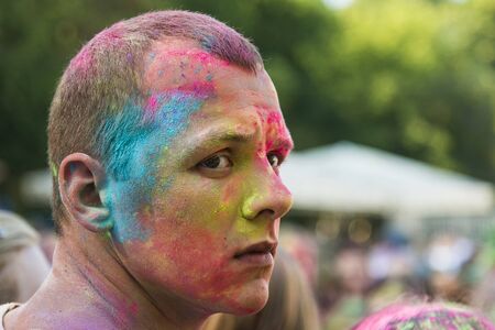 Lviv, Ukraine - August 30, 2015: Man watches festival of colors in a city park in Lviv.のeditorial素材