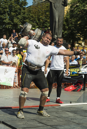 Lviv, Ukraine - July 05, 2015: Strongman competitions raises dumbbell hand in Yarych street Fest 2015  near centrum  of  Lviv  city.のeditorial素材