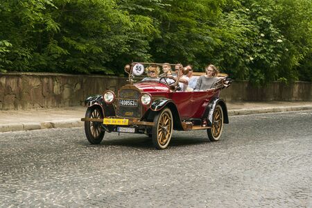 Lviv, Ukraine - June 2, 2019: Old retro car Willys Knight (1920)  with its owner and  unknown passenger taking participation in race Leopolis grand prix 2019, Ukraine.のeditorial素材