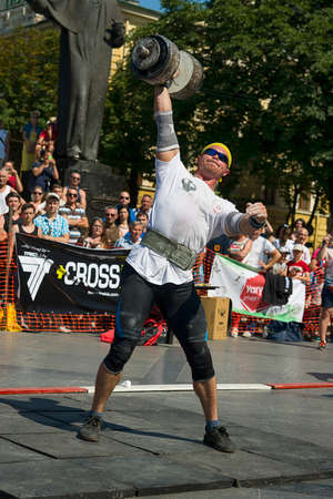 Lviv, Ukraine - July 05, 2015: Strongman competitions raises dumbbell hand in Yarych street Fest 2015 near centrum of Lviv city.のeditorial素材