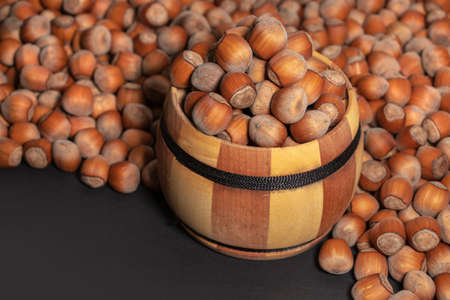 Filtered image of Hazelnuts in a wooden bowl on darck background.の写真素材