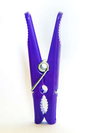 Purple plastic clothespins on a white background.の写真素材