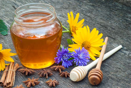 Honey in jar with honey spoon on vintage wooden backgroundの写真素材
