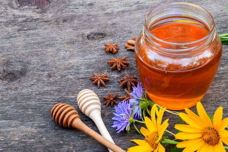 Honey in jar with honey spoon on vintage wooden backgroundの写真素材