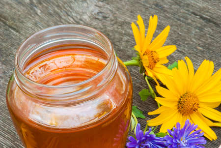 Honey in jar with honey spoon on vintage wooden backgroundの写真素材