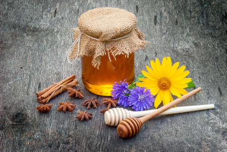 Honey in jar with honey spoon on vintage wooden backgroundの写真素材