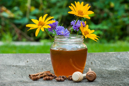 Honey in jar with honey spoon on vintage wooden background