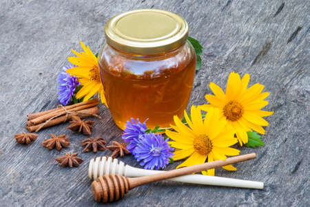 Honey in jar with honey spoon on vintage wooden backgroundの写真素材