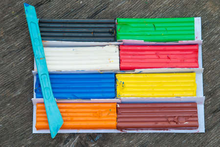 Set of colorful plasticine sticks isolated on wooden background. Rainbow modeling clay piece for children play and creativityの写真素材