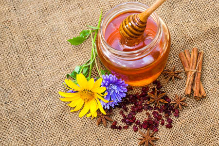 Honey in jar with honey spoon on vintage wooden backgroundの写真素材