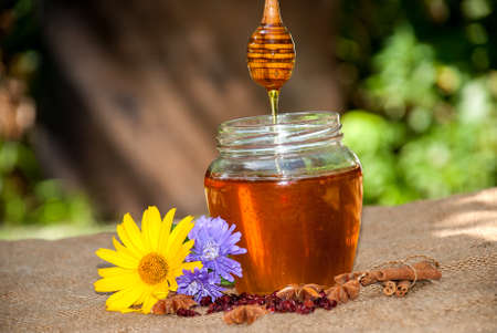 Honey drip in jar on the table.の写真素材
