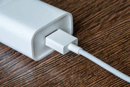 White electrical usb cord and charger plug in wall outlet