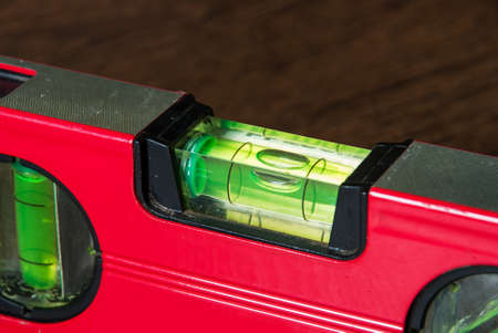 Level tool with red aluminum steel alloy body and green water bar for precise measurementの写真素材