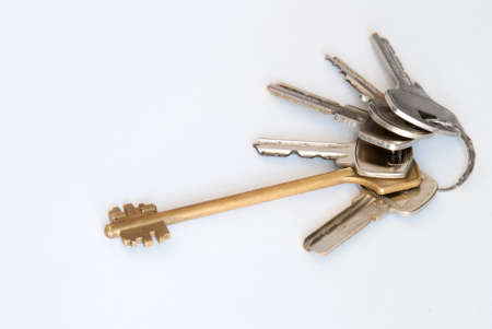 A bunch of modern door keys on ring on white background.の写真素材