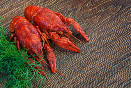 Boiled crayfish with dill on wooden background.