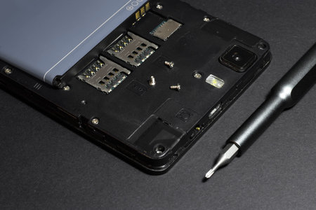 Repair smartphone, disassembled phone with a screwdriver.の写真素材