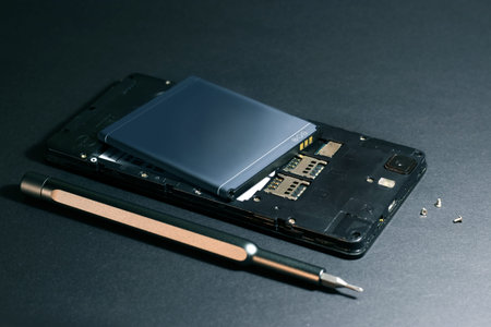 Repair smartphone, disassembled phone with a screwdriver.