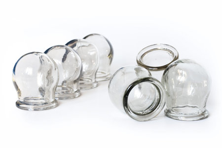 Massage jars for therapeutic massage on white background.