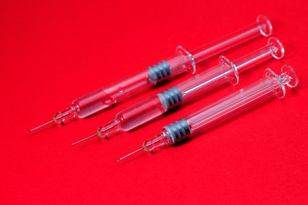 Syringes isolated on red background.