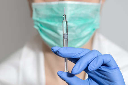 healthcare and medical concept - close up of female doctor holding syringe with injection.の写真素材