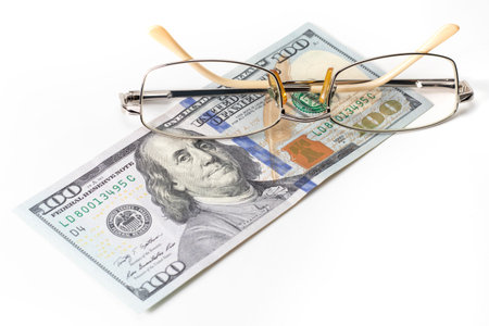 Closeup glasses on US 100 hundred dollar bill or banknote background.