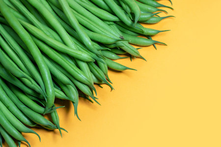 Green beans on a yellow background. copy space