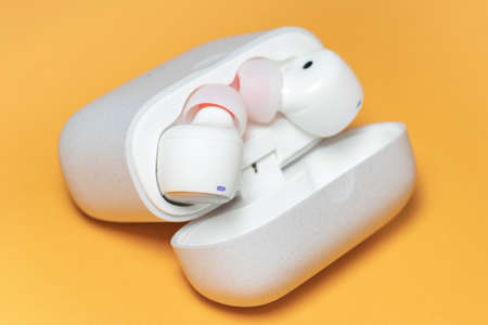Wireless headphones on a yellow background with case.の写真素材