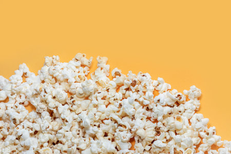 Tasty salted popcorn on yellow background